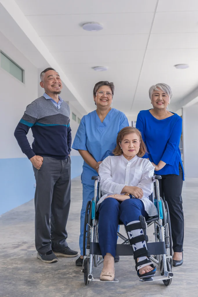 Fotografía de una familia y una enferma saliendo del hospital con una de ella en silla de ruedas