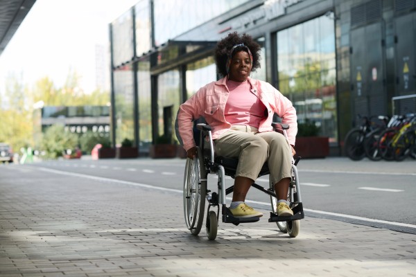 Vista general de una mujer en la calle gracias a los beneficios de usar una silla de ruedas.