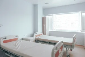 Habitación de hospital limpia con dos camas vacías, fundamental para la venta de equipo médico y recuperación.