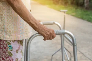 Mujer mayor usando un andador, mostrando apoyo para la movilidad. Clave para la venta de equipo médico de asistencia.